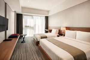 Golden Tulip Incheon Airport Hotel في انشيون: غرفة فندقية بسريرين وتلفزيون بشاشة مسطحة