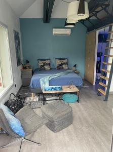 ein Schlafzimmer mit einem Bett, einem Tisch und einem Sofa in der Unterkunft MealSaveurs & SPA in La Buisse