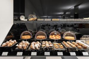 a display case filled with lots of different types of donuts at LHP Napoli Palace & SPA in Naples