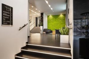 a lobby with stairs and a green wall at LHP Napoli Palace & SPA in Naples