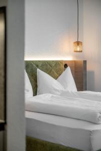 a bedroom with a bed with white sheets and pillows at Camping Sölden Apartments in Sölden