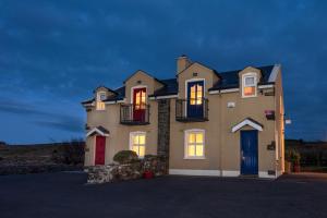a large house with its lights on at Atlantic View Cottages in Doolin