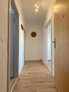 an empty hallway with white walls and wooden floors at Gästewohnung KL. WZL 31_7 