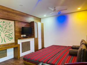 a room with a bed and a tv on a wall at TCS SUITES in Cochin