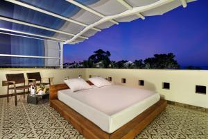1 dormitorio con 1 cama en el balcón en Crystal Aura Beach Resort & Spa - Ultimate All Inclusive, en Kemer