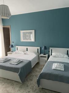 2 camas en un dormitorio con paredes azules en Interno2 Bari Centrale, en Bari