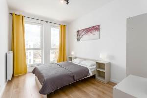 sypialnia z łóżkiem i dużym oknem w obiekcie Chill Apartments Warsaw Airport w Warszawie