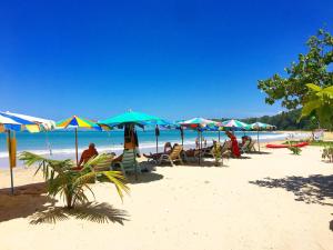 a group of people sitting under umbrellas on a beach at 1b pool, Gym, walk to lovely Naiyang Beach in Nai Yang Beach