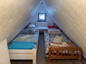 a attic room with three bunk beds in it at Vikendica Golija in Novi Pazar