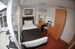 une petite chambre avec un lit et un bureau dans l'établissement Palace Point Hotel, à Istanbul