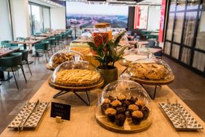 uma mesa com várias bandejas de pastelaria e sobremesas em MOVIE MOVIE HOTEL em Roma