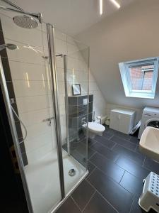 W łazience znajduje się prysznic, umywalka i toaleta. w obiekcie Haus Zuckersnuut w mieście Dornum