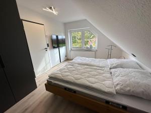 a bedroom with a large bed with a window at Haus Zuckersnuut in Dornum