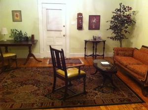 a living room with a couch and a chair at Brooks House Suites in Mineola