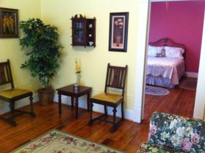 a living room with a bed and a table and chairs at Brooks House Suites in Mineola