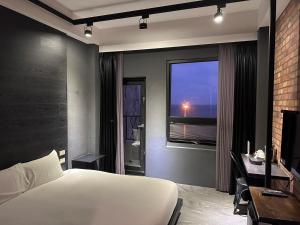um quarto com uma cama branca e uma janela em 窗外的海 - 海洋公園旁 em Yanliau