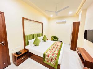 1 dormitorio con 1 cama con colcha verde en Hotel The Orchid Tree Amritsar - walking from Golden Temple en Amritsar