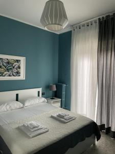 a blue bedroom with a bed with towels on it at Interno2 Bari Centrale in Bari