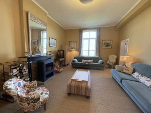 a living room with blue couches and a tv at La ferme du Bailly in Couvin