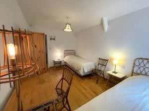 een kamer met 2 bedden en een tafel en stoelen bij La ferme du Bailly in Couvin