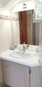 La salle de bains est pourvue d'un lavabo blanc et d'un miroir. dans l'établissement Appartement de 2 chambres a Poggio d'Oletta a 6 km de la plage, à Poggio-dʼOletta