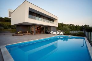 a house with a swimming pool in front of a house at Traumvilla auf Krk in Malinska