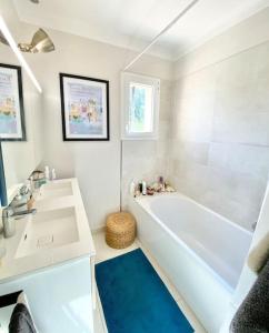 een witte badkamer met een bad en een wastafel bij VILLA PIERLOU Piscine proche mer pour 6/7 pers in Saint-Raphaël