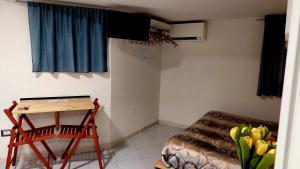 um quarto com uma secretária, uma cama e uma mesa em Giulia's Home Pompei em Pompeia