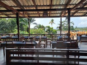 a restaurant with tables and chairs and palm trees at Casa Cantagalo - Guest House & Bar Restaurant in SantʼAna