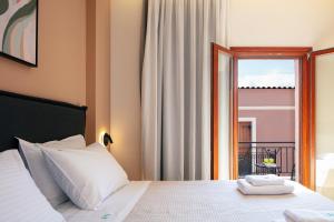een slaapkamer met een bed en uitzicht op een balkon bij Centro Storico in Chania
