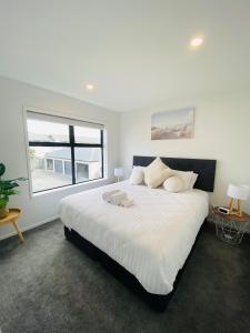 een slaapkamer met een groot wit bed en een raam bij Home sweet home Christchurch Centre in Christchurch