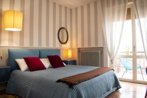 een slaapkamer met een blauw bed met rode kussens bij Caserma Ederle Budget Apartment x3 in Vicenza