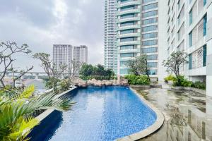 a swimming pool in a city with tall buildings at RedLiving Apartemen Grand Kamala Lagoon - Aoklah Property Tower Barclay North in Bekasi