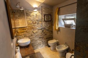 a stone bathroom with a sink and a toilet at Tuttaterra in Serra San Quirico