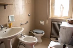baño con lavabo y aseo y ventana en Caserma Ederle Budget Apartment x3 en Vicenza