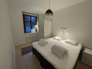 1 dormitorio con 1 cama blanca grande y 2 almohadas en Topp lägenhet 3a en Estocolmo