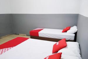 two beds in a room with red and white pillows at OYO Hotel Brás in Sao Paulo
