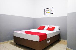 a bedroom with a bed with red and white pillows at OYO Hotel Brás in Sao Paulo