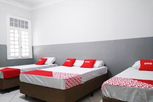 Duas camas num quarto com almofadas vermelhas em OYO Hotel Brás em São Paulo