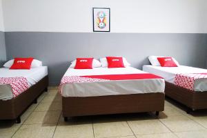 Duas camas num quarto com almofadas vermelhas em OYO Hotel Brás em São Paulo