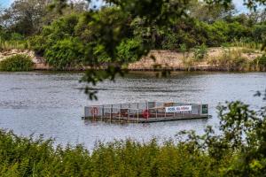 a barge in the middle of a body of water at Kubu & Kwena Lodge in Katima Mulilo