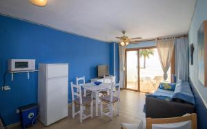 a blue living room with a table and a refrigerator at Primera línea Playa Romana 17 - ALBERT VILLAS in Alcossebre