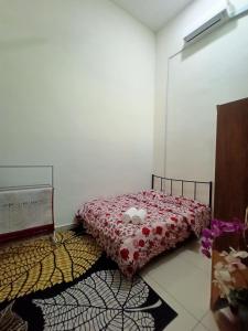 um quarto com uma cama com um edredão vermelho em Homestay KiTa malays only em Alor Setar