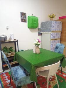 uma mesa com uma toalha de mesa verde e cadeiras em Homestay KiTa malays only em Alor Setar