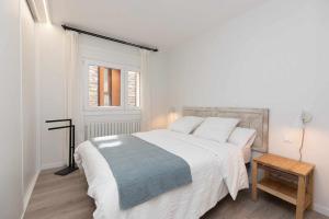 a white bedroom with a large bed and a window at Sky Biescas I by BeValle in Biescas