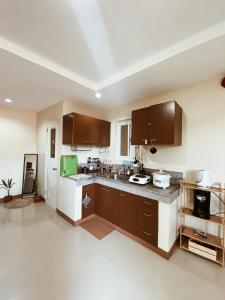 a kitchen with brown cabinets and a counter top at Dayun La Union, Transient House in San Fernando