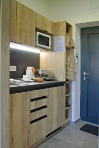uma cozinha com armários de madeira e um micro-ondas em New Pension at ROTOR Brewery em Kunowitz