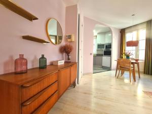 een woonkamer met een dressoir en een spiegel bij Dos Torres Arte en Balcones - Calle Alfonso I in Zaragoza