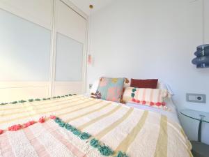 een slaapkamer met een bed met een gestreepte deken bij Dos Torres Arte en Balcones - Calle Alfonso I in Zaragoza