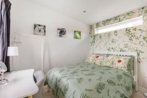 a bedroom with a bed with a green comforter at Cosy and modern 1 bedroom garden house - very dog friendly! in Tarves